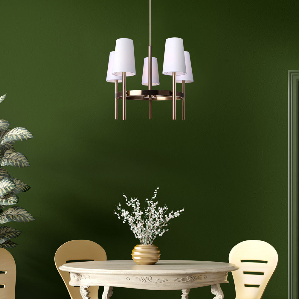 photo of a dining room, painted kelly green, with a white round dining table and two chairs, a large plant to the left, and a 5 light chandeiler in gold finish with 5 white tappered shades hanging over the table